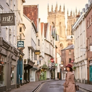 Woman wearing trench coat and pink hat walking