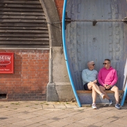 Two men sit in a bench seat created form a row boat