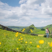 A man and a woman walk in open countryside