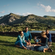 Friends having a picnic in grassland by a glacially formed lake.
