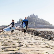 Windsurfer walking across the exposed causeway path of stone