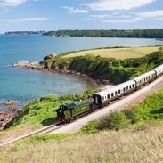 Dampfzug auf einer Bahnstrecke entlang der Küste
