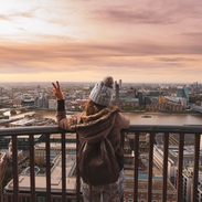Woman at the top of St Paul's dome at sunrise with city view