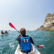 People kayaking along the shores of coastline