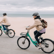 Two people cycling past Bournemouth's seafront.