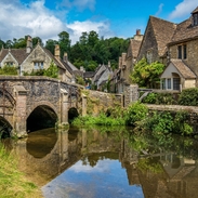 Blauer Himmel und Spiegelungen im malerischen Cotswold-Dorf Castle Combe