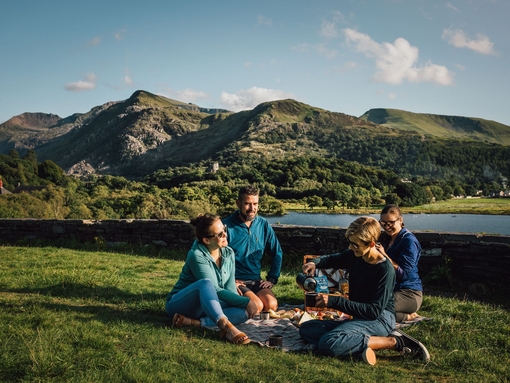 Friends having a picnic in grassland by a glacially formed lake.